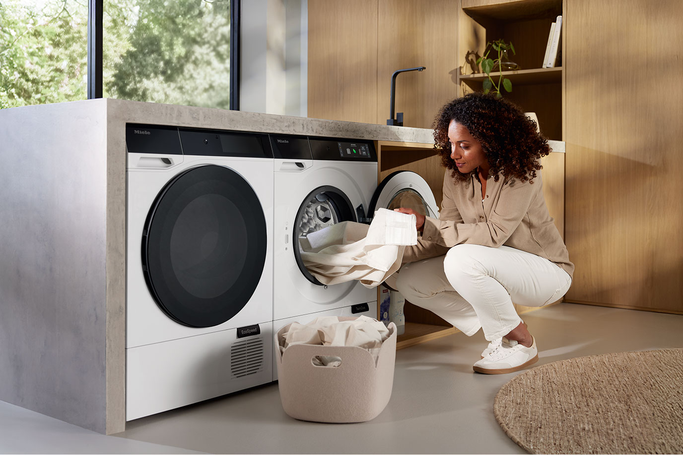 Kobieta wyjmuje pranie z pralki Miele