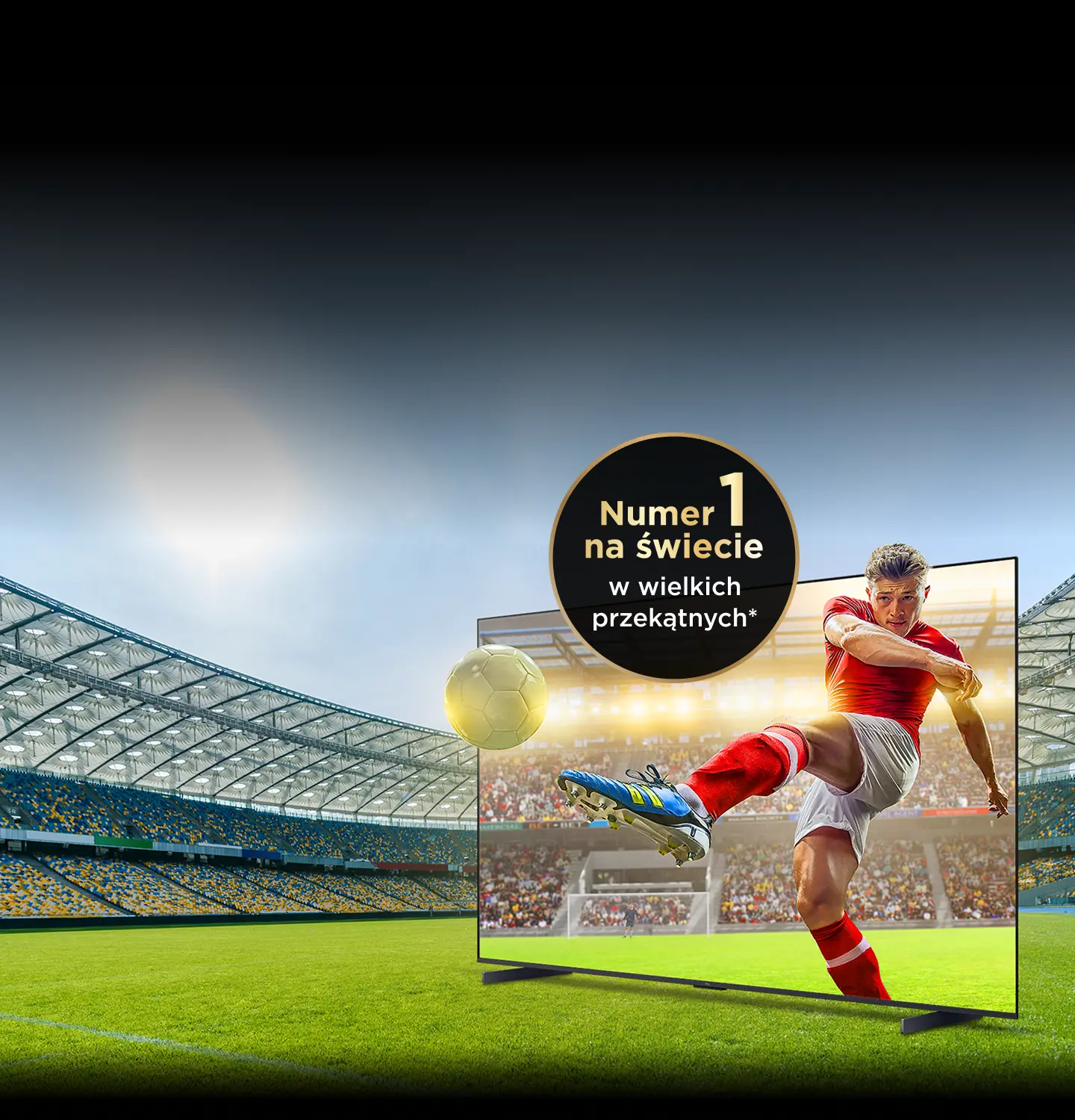 Piłkarz strzelający gola na ekranie dużego telewizora stojącego na murawie stadionu. Napis: Numer 1.