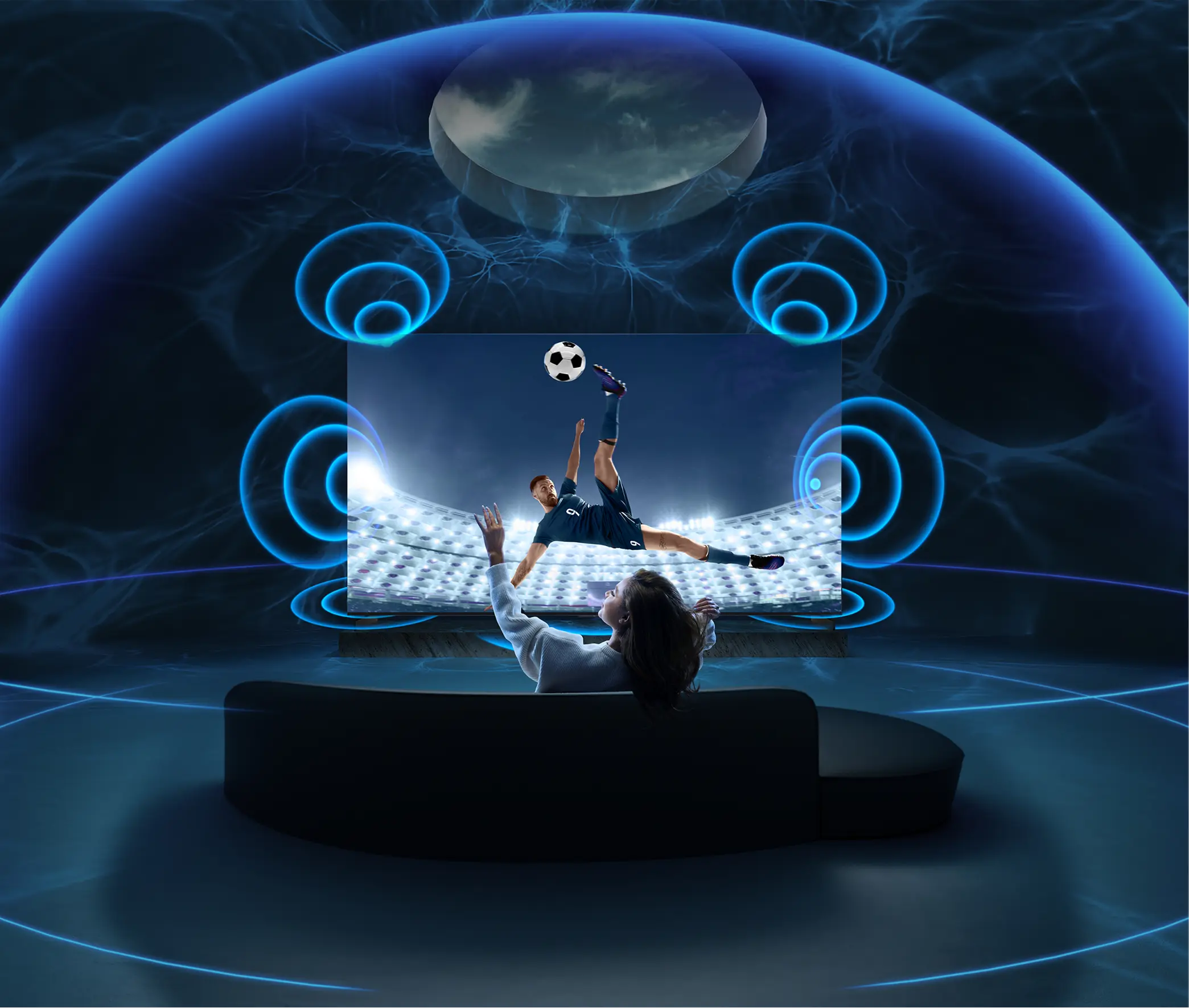 Kobieta na sofie ogląda mecz na tv w ciemnym pomieszczeniu z niebieską grafiką dźwięku.