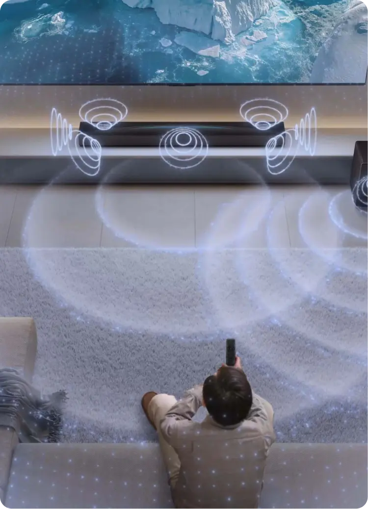 Wizualizacja fal dźwiękowych rozchodzących się z soundbaru w stronę osoby siedzącej na kanapie.