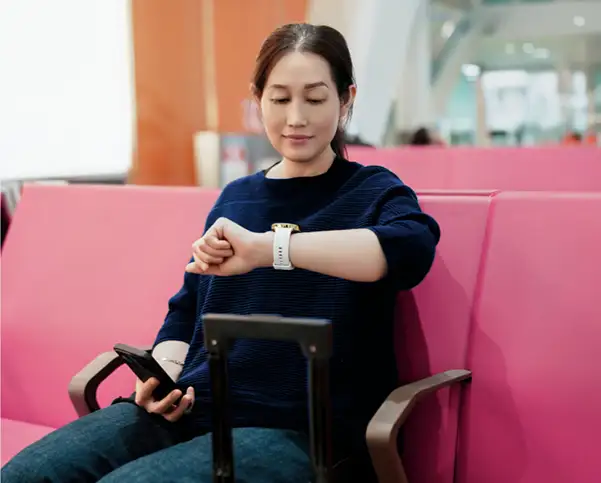 Kobieta sprawdza smartwatch Hama siedząc na ławce