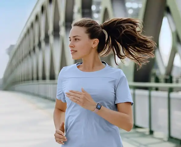 Kobieta biegnie po moście i korzysta ze smartwatcha Hama