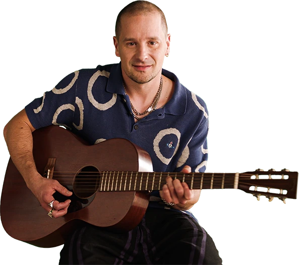 Mężczyzna siedzący z gitarą akustyczną