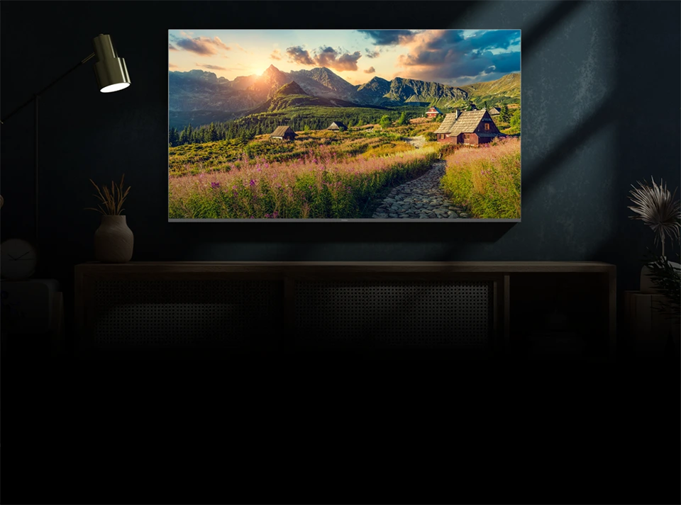 Telewizor ścienny Haier w ciemnym wnętrzu wyświetlający górski krajobraz