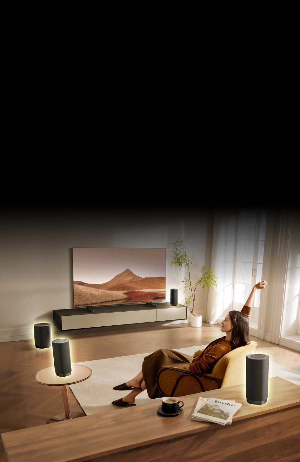 Kobieta relaksuje się w salonie z kinem domowym i czterema bezprzewodowymi głośnikami Z100