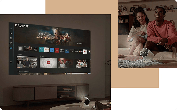 Projektor The Freestyle wy&sacute;wietla na &sacute;cianie ekran z aplikacjami Smart TV. Po drugiej stronie siedz&aogon; dwie osoby. 
