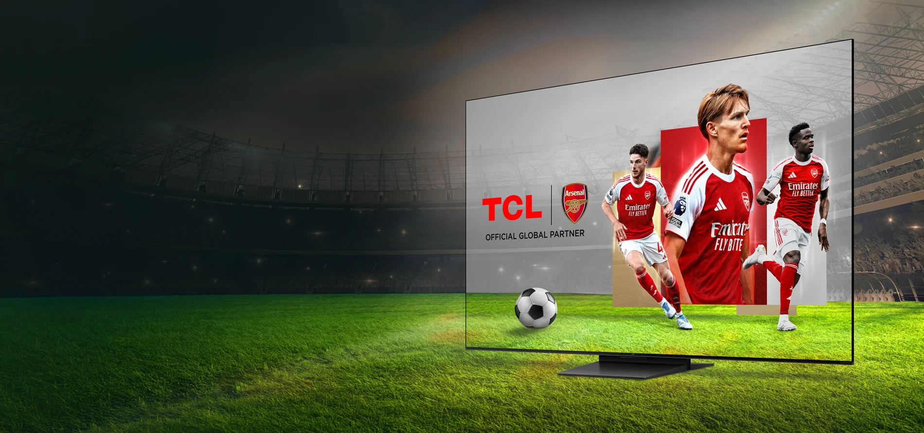 Telewizor TCL z piłkarzami Arsenalu na murawie stadionu z piłką i logo Official Global Partner.