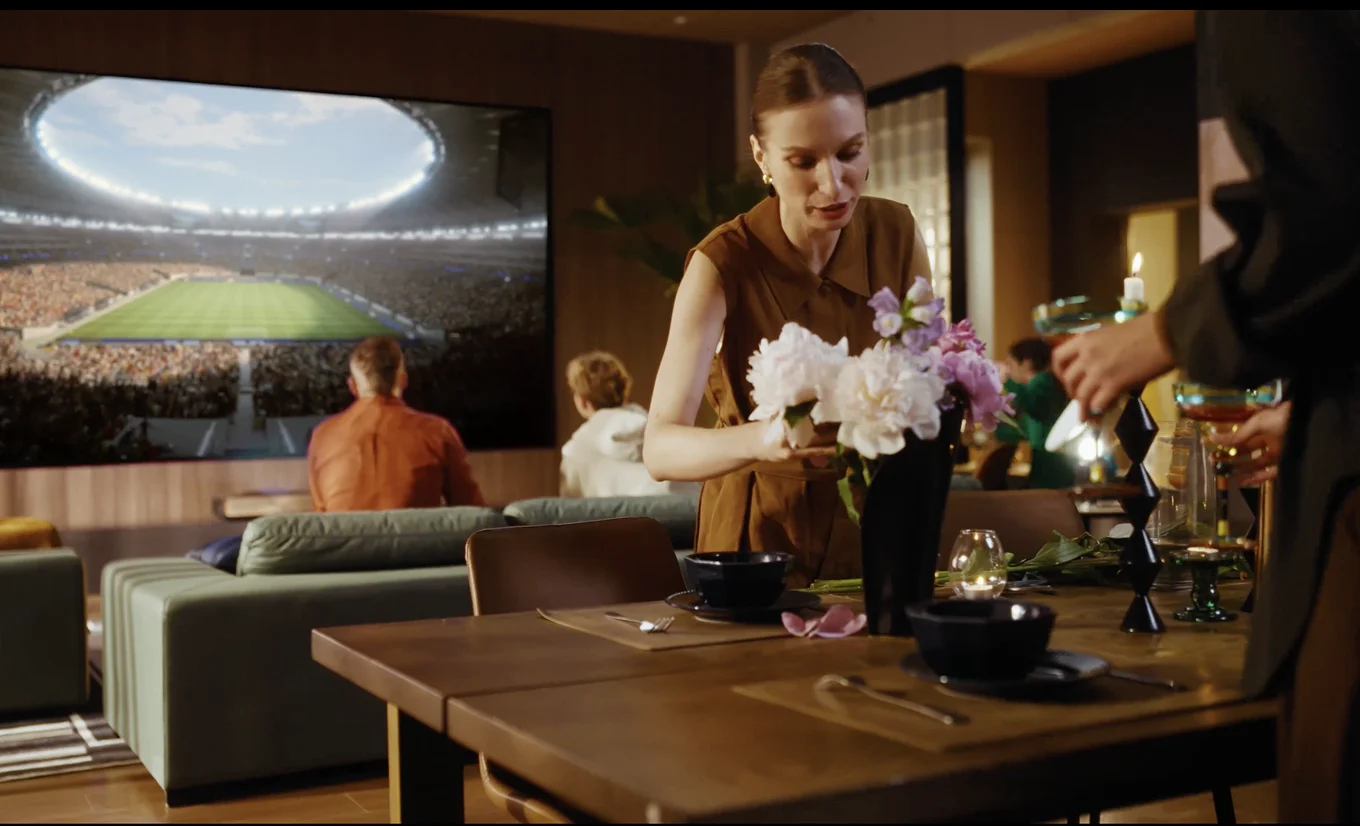 Kobieta oglądająca kwiaty w tle obraz wyświetlony z projektora przedstawiający widok stadionu piłkarskiego