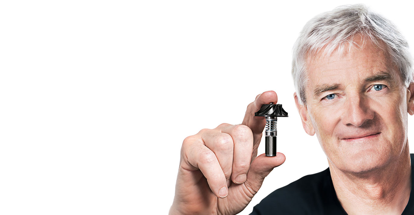 James Dyson, założyciel marki, trzyma w dłoni silnik cyfrowy skonstruowany przez inżynierów marki Dyson