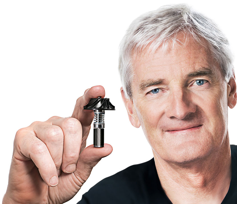 James Dyson, założyciel marki, trzyma w dłoni silnik cyfrowy skonstruowany przez inżynierów marki Dyson