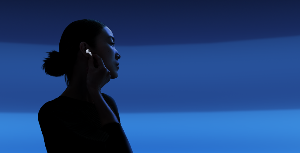 Osoba trzyma końcówkę AirPods 5 kciukiem i palcem wskazującym, żeby przełączyć się między trybami słuchania
