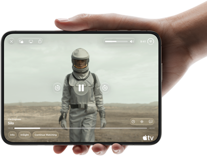 Całkowicie rozłożony iPhone Duo trzymany w jednej dłoni w pozycji poziomej, na wyświetlaczu wewnętrznym widać serial „Silos” w apce Apple TV