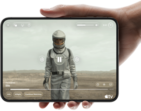 Całkowicie rozłożony iPhone Duo trzymany w jednej dłoni w pozycji poziomej, na wyświetlaczu wewnętrznym widać serial „Silos” w apce Apple TV