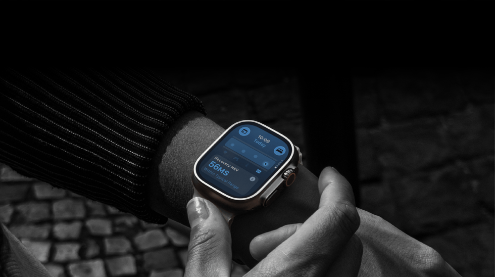 Osoba z założonym na nadgarstek Apple Watch Ultra 4, odczyty parametrów życiowych w dzień są lekko odbiegające od normy