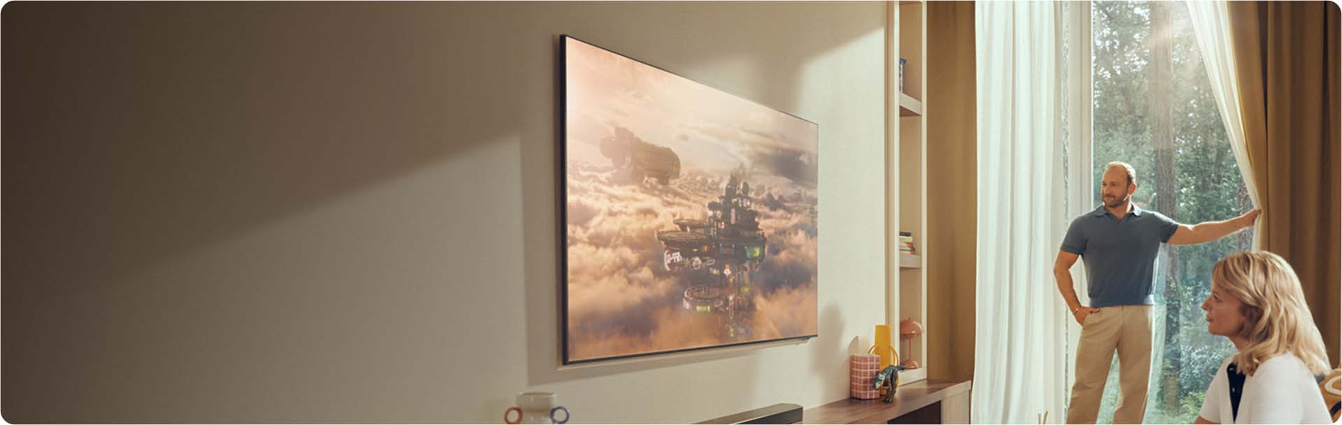 Du&zdot;y telewizor znajduje si&eogon; w jasnym salonie z ro&sacute;linami i r&oacute;&zdot;nymi ozdobami.