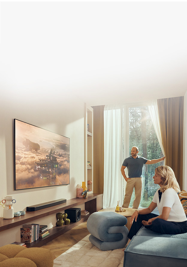 Du&zdot;y telewizor znajduje si&eogon; w jasnym salonie z ro&sacute;linami i r&oacute;&zdot;nymi ozdobami.