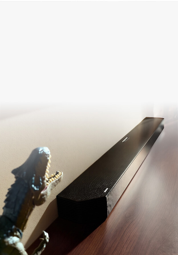 Czarny soundbar znajduje si&eogon; na p&oacute;lce w towarzystwie kolorowych wazon&oacute;w i lamp.
